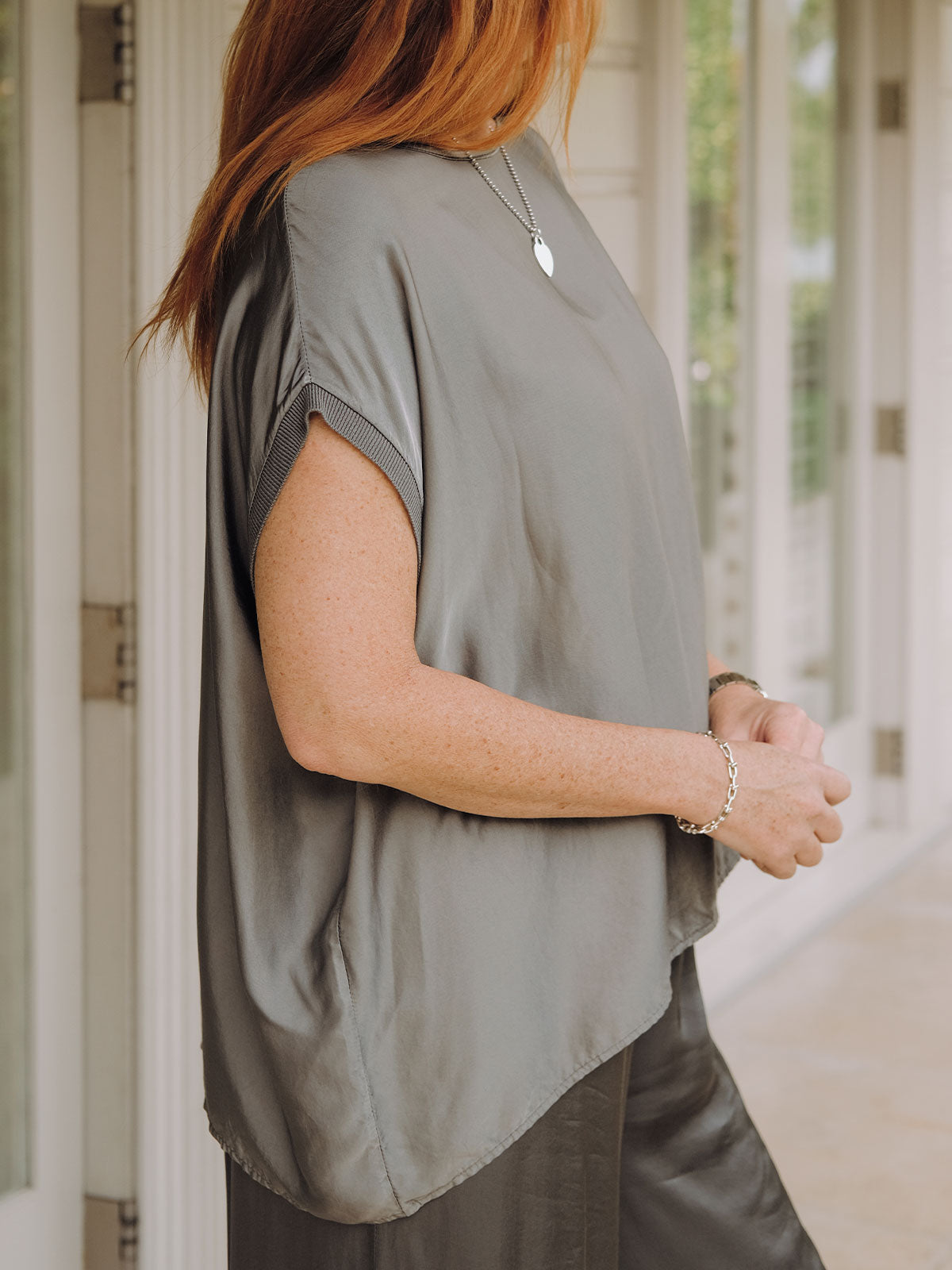 Mamapapa Tobi Flowy Tee in Charcoal - Side view detail showing the relaxed silhouette and elegant silky drape of the flowy t-shirt, highlighting the fine knit cuff and clean side seam construction in sophisticated charcoal grey