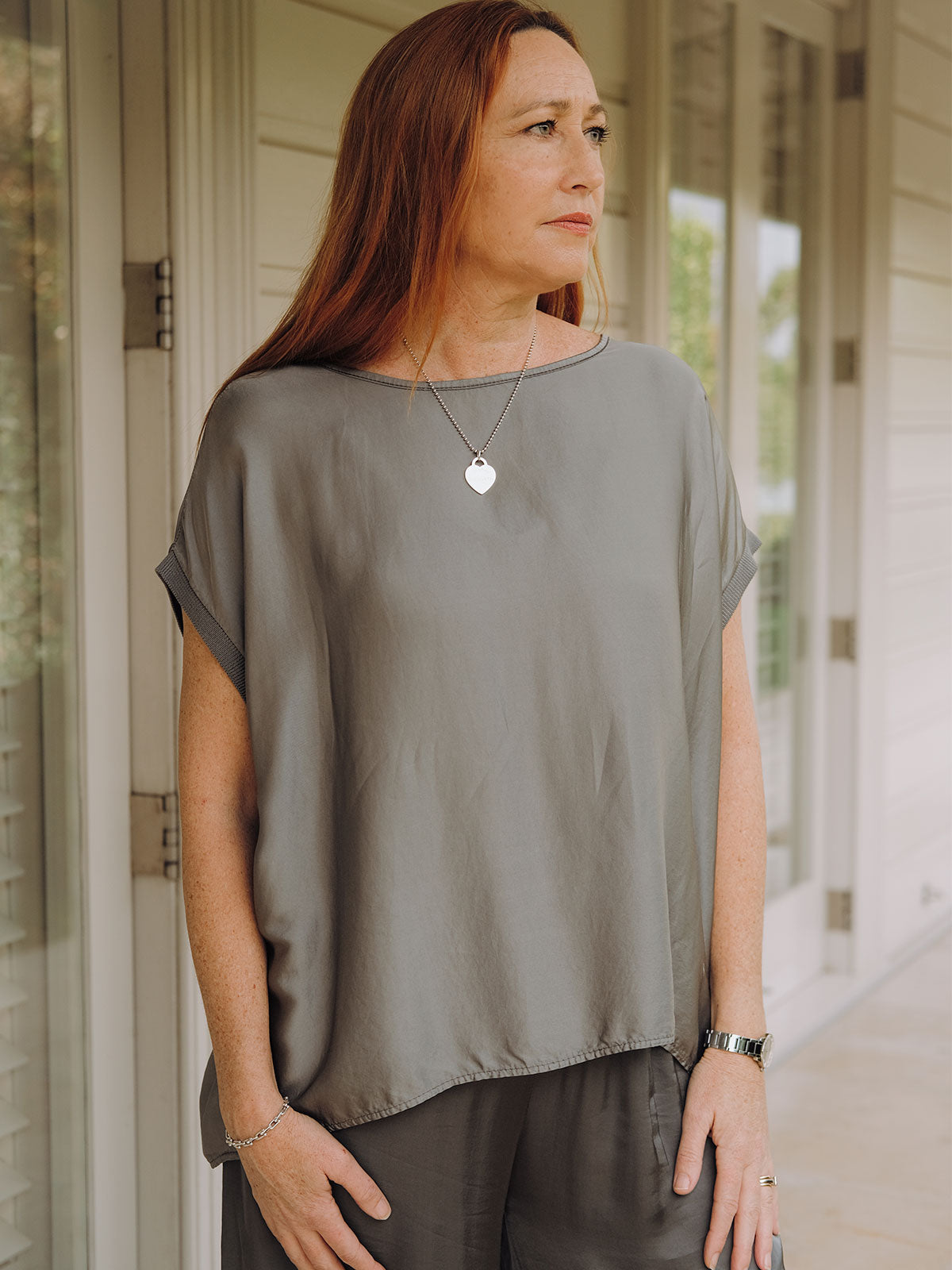Mamapapa Tobi Flowy Tee in Charcoal - Close-up detail showcasing the fine knit cuff and flattering wide boat neckline, highlighting the elegant drape and soft texture of the relaxed-fit t-shirt in versatile charcoal grey shade
