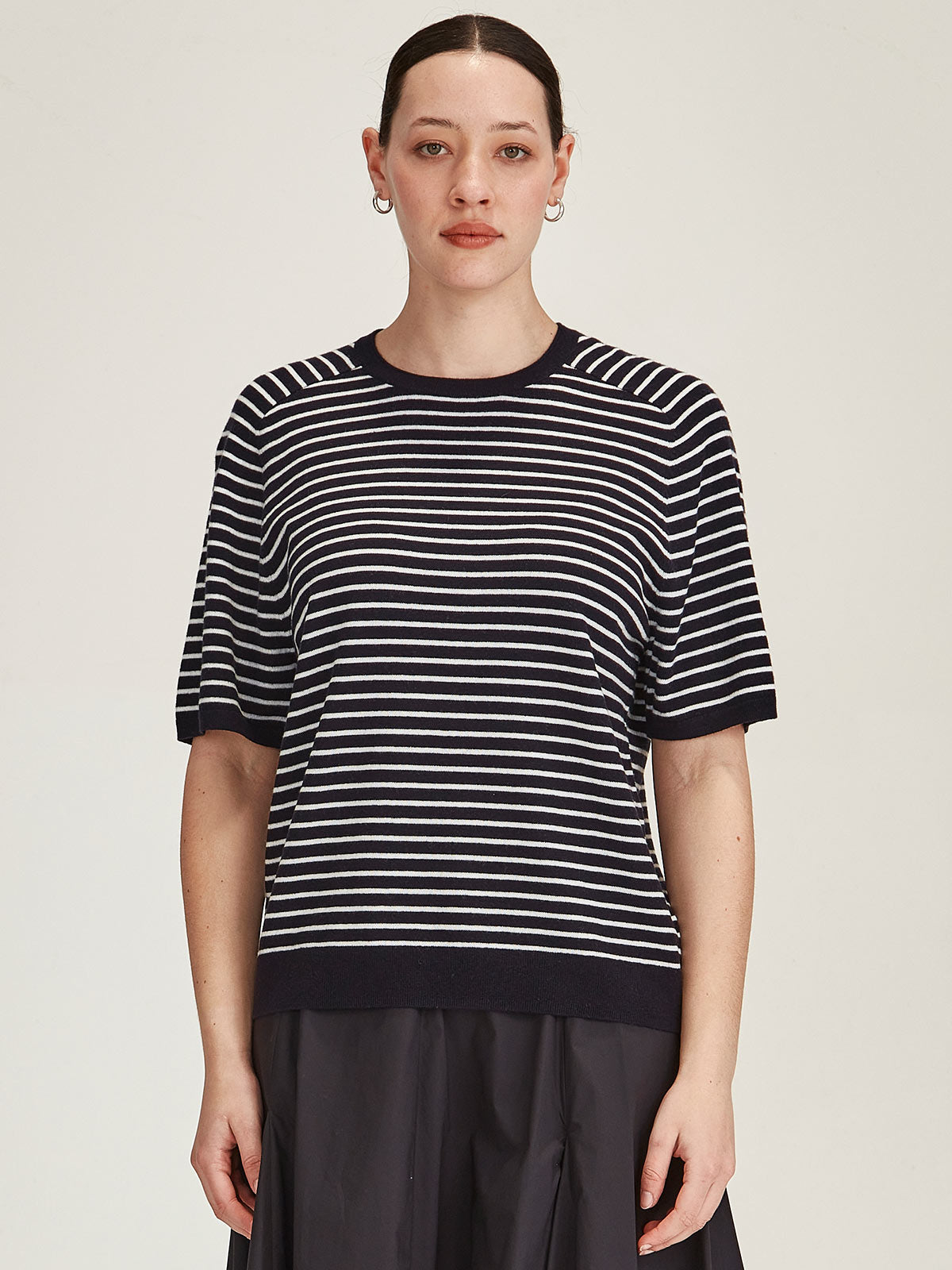 woman wearing Sills Cecilia Stripe knitted Tee t-shirt in off white and navy stripe on grey background