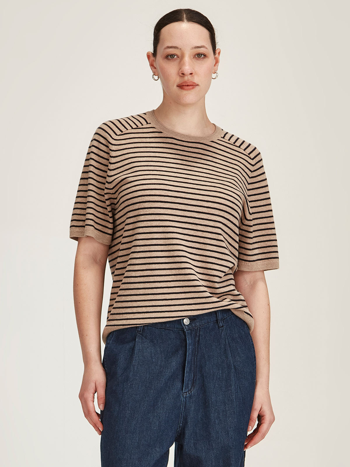 woman wearing Sills Cecilia Stripe knitted Tee t-shirt in off beige and navy stripe on grey background