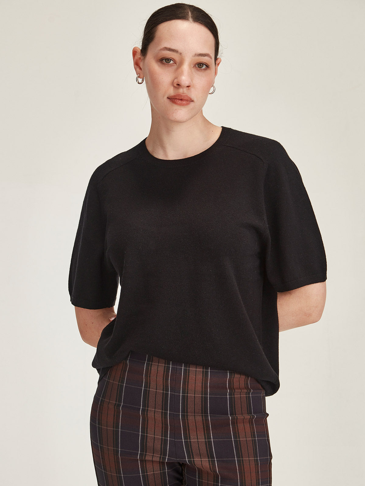 close up of a woman wearing a black Sills Cecilia knitted Tee t-shirt on grey background