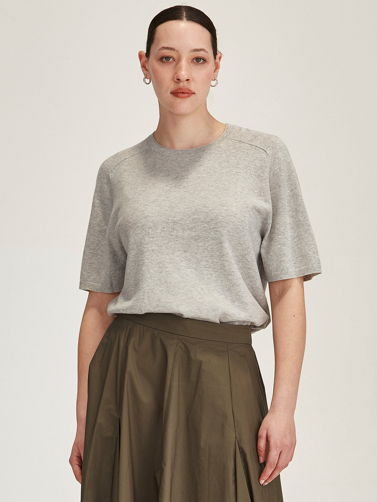 close up of a woman wearing a grey Sills Cecilia knitted Tee t-shirt on grey background