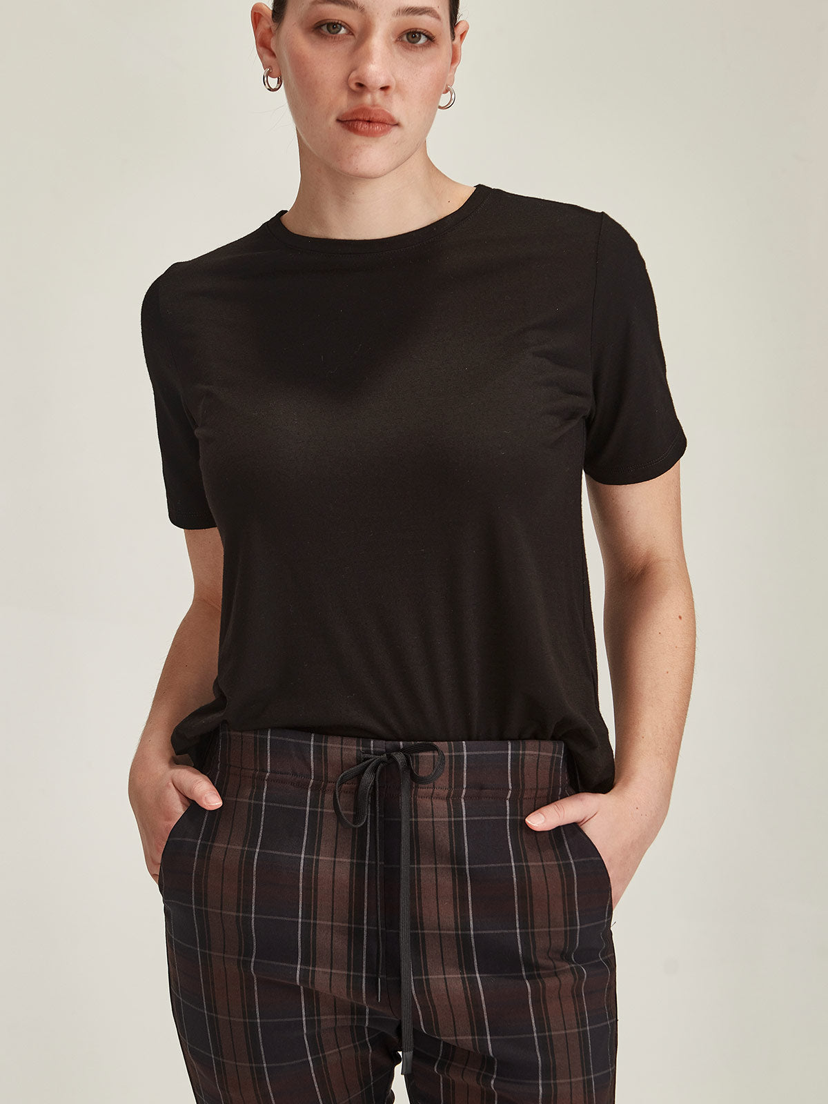 close up of woman against grey background wearing black Sills merino blend Lena Luxe crew neck t-shirt