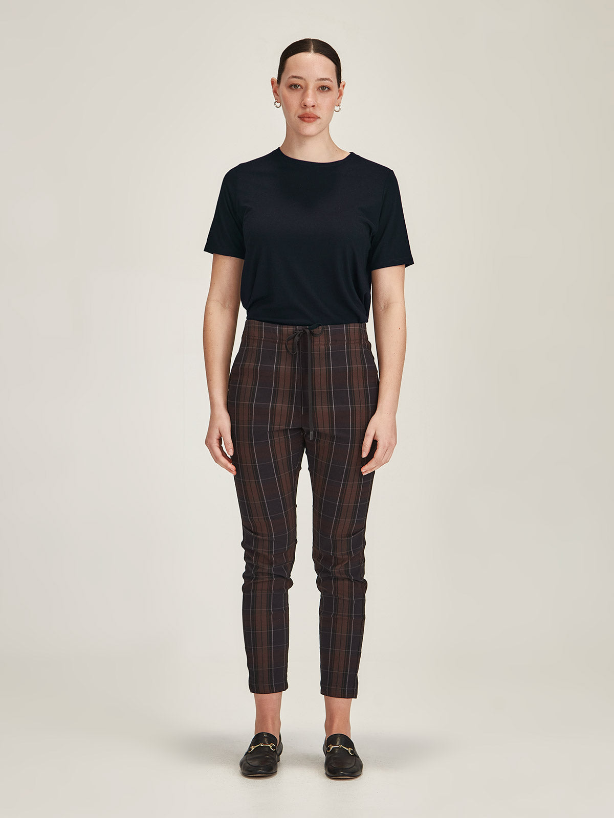 woman against grey background wearing Sills navy merino blend Lena Tee with chocolate plaid Emily Joggers