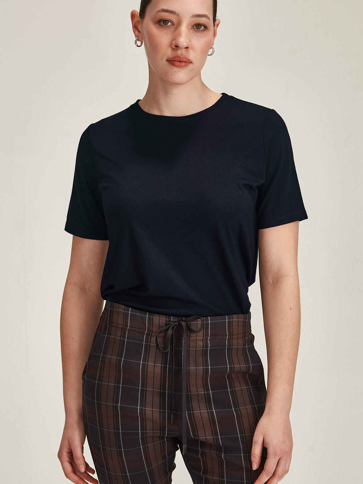 close up of woman against grey background wearing navy Sills merino blend Lena Luxe crew neck t-shirt