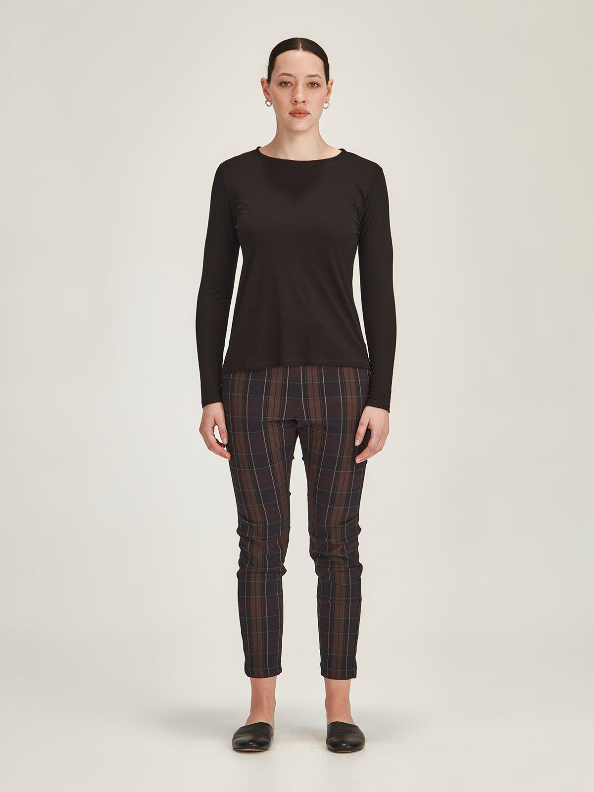 woman against grey background wearing Sills black merino blend Lena long sleve Tee with chocolate plaid Hpeburn pull on pants