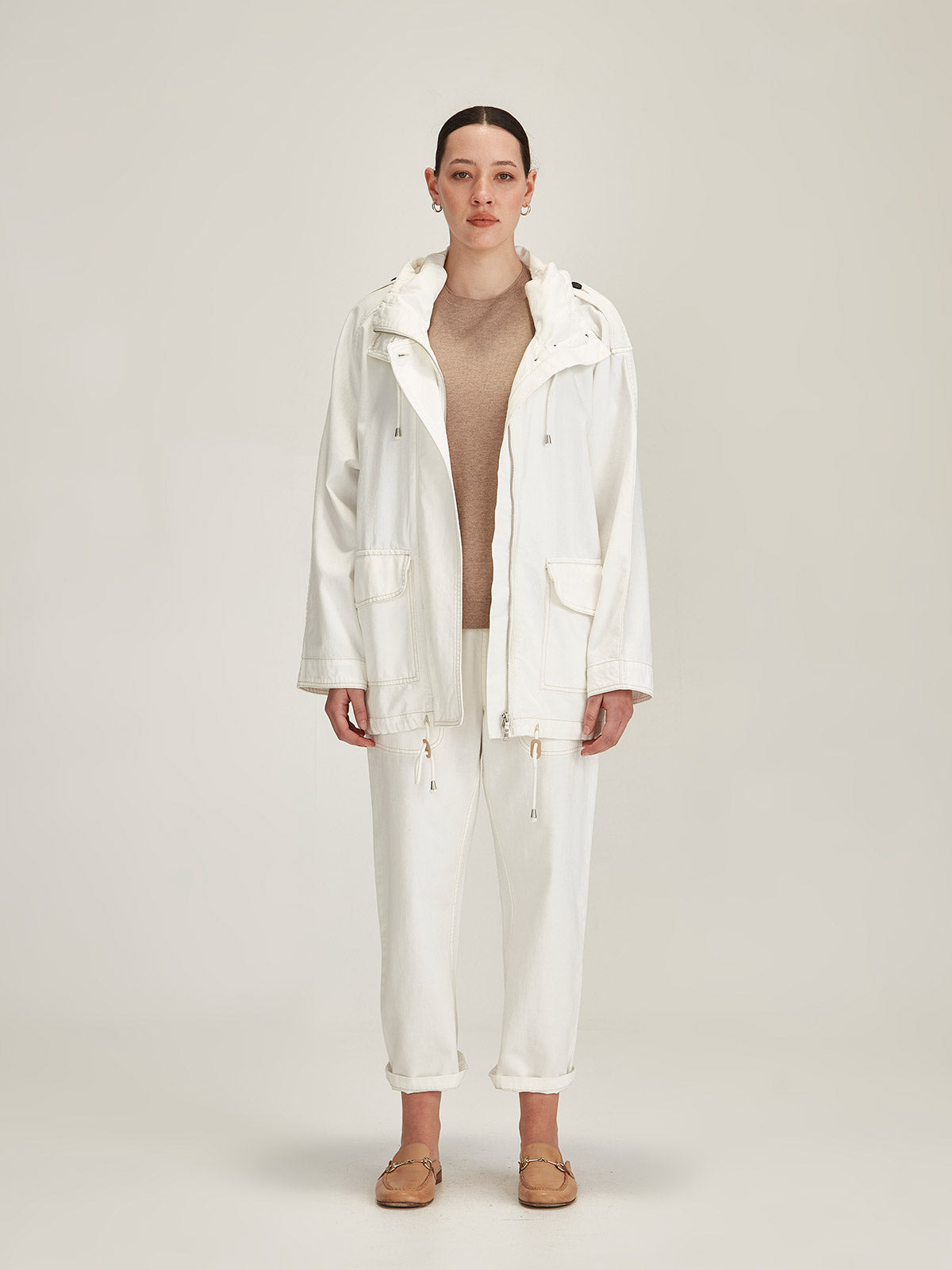 woman wearing Sills white denim Dover Chalk Parka and white Ginza Denim Pants against grey background