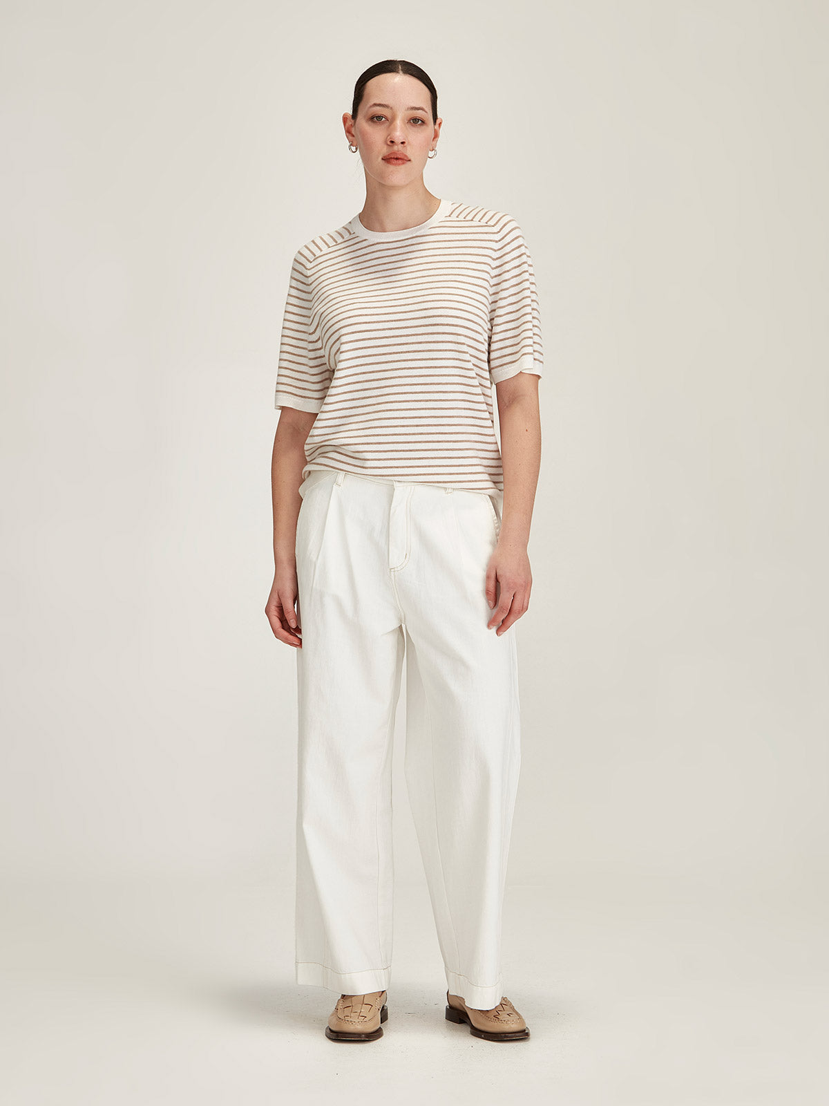 woman wearing Sills Cecilia striped knitted t-shirt and Britt wide leg white jeans on grey background
