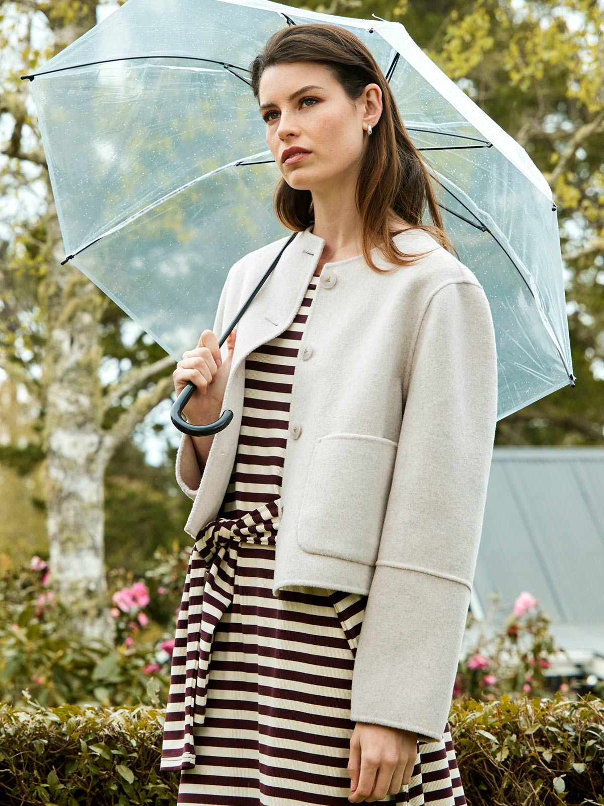 Woman outdoors with umbrella wearing Sills Emiko wool blend jacket in Perla over cocoa striped Gianna t-shirt dress