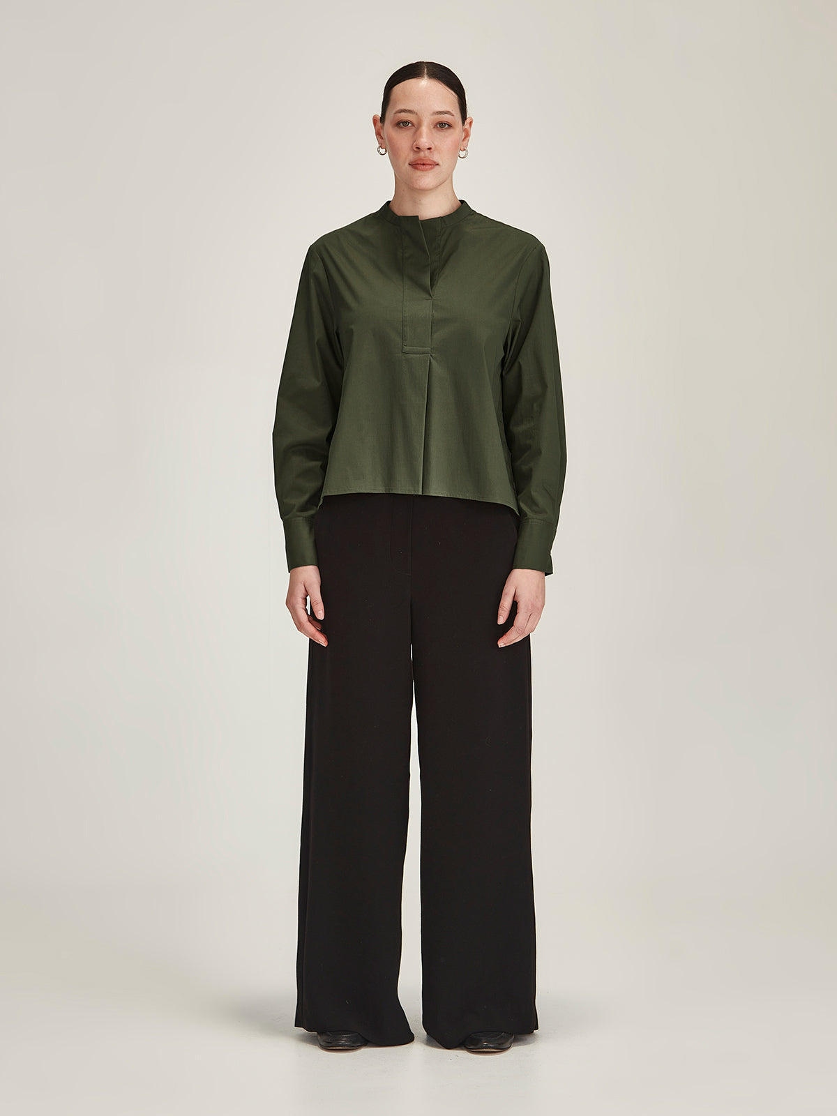 woman wearing khaki Corso shirt and black Luca wide leg pant on grey background