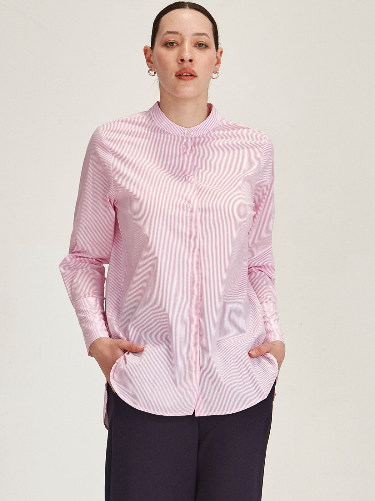 close up of woman wearing Sills pink Koda Striped Shirt on grey background