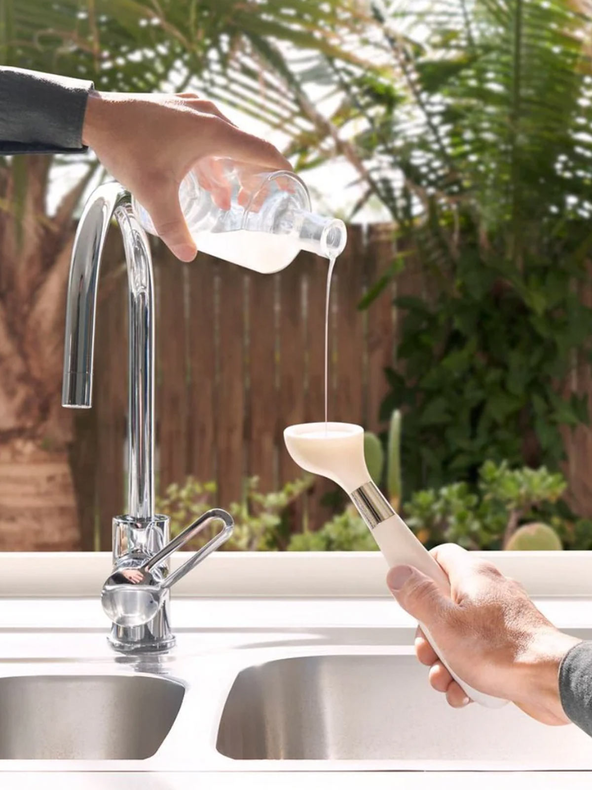 The ONE BRUSH by Yeseco - Close-up of white eco-friendly dish brush demonstrating soap dispensing feature, sustainable kitchen scrubber with refillable soap reservoir and magnetic storage system.