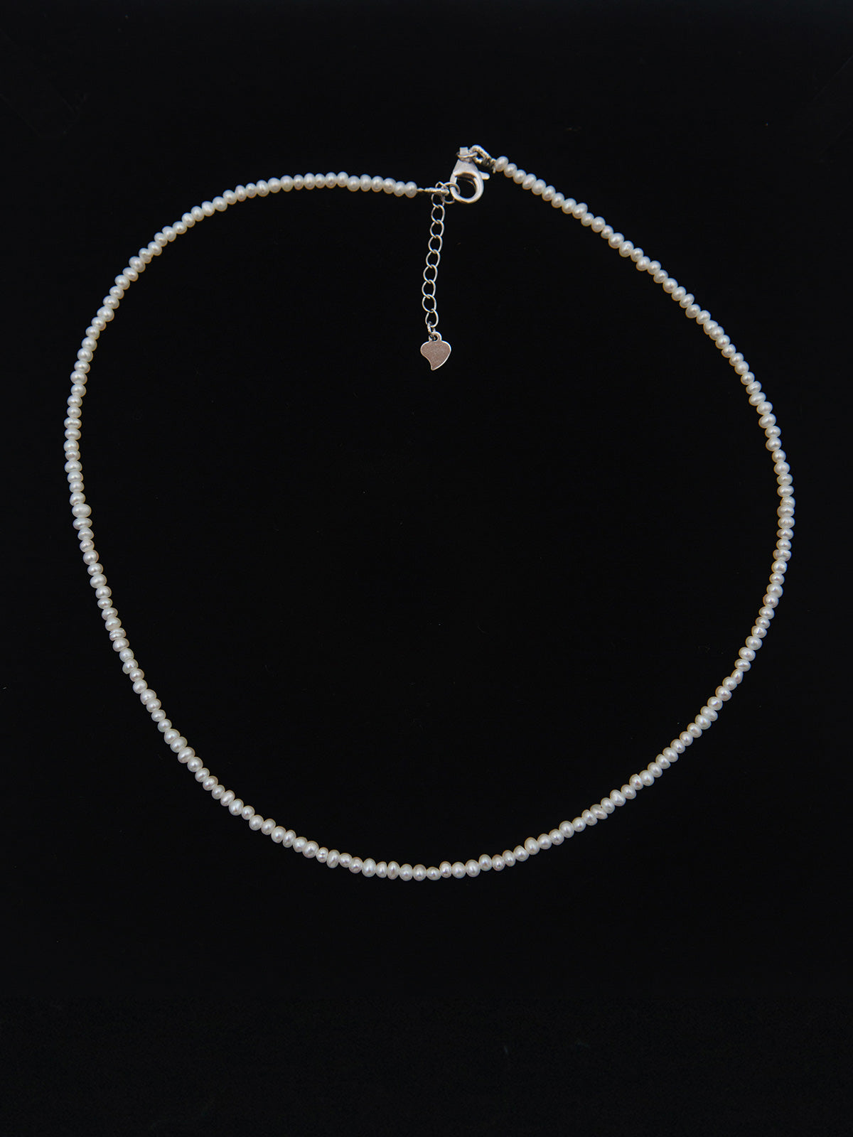 Mini pearl necklace on a black background