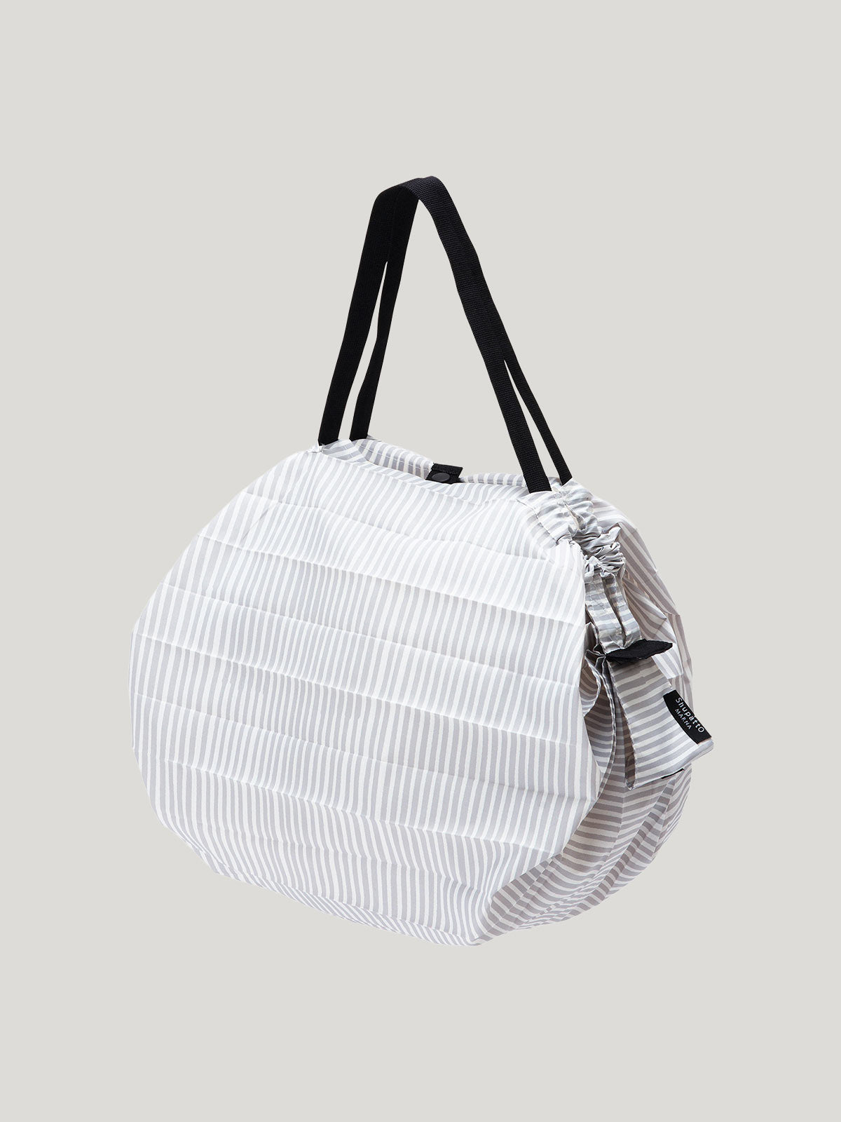 Foldable, reusable shopping bag in vertical striped light grey and white pattern on a grey background.