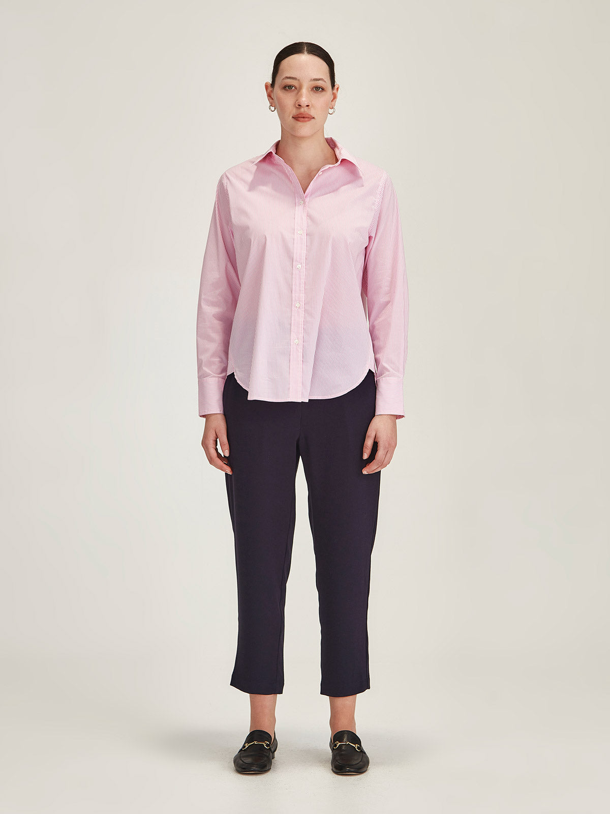 woman wearing baby pink Sills Princeton Striped Shirt with navy Joseph crepe Romily Pant against grey background