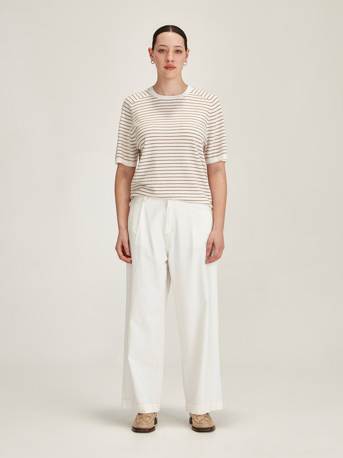 woman wearing Sills Cecilia striped knitted t-shirt and Britt wide leg white jeans on grey background