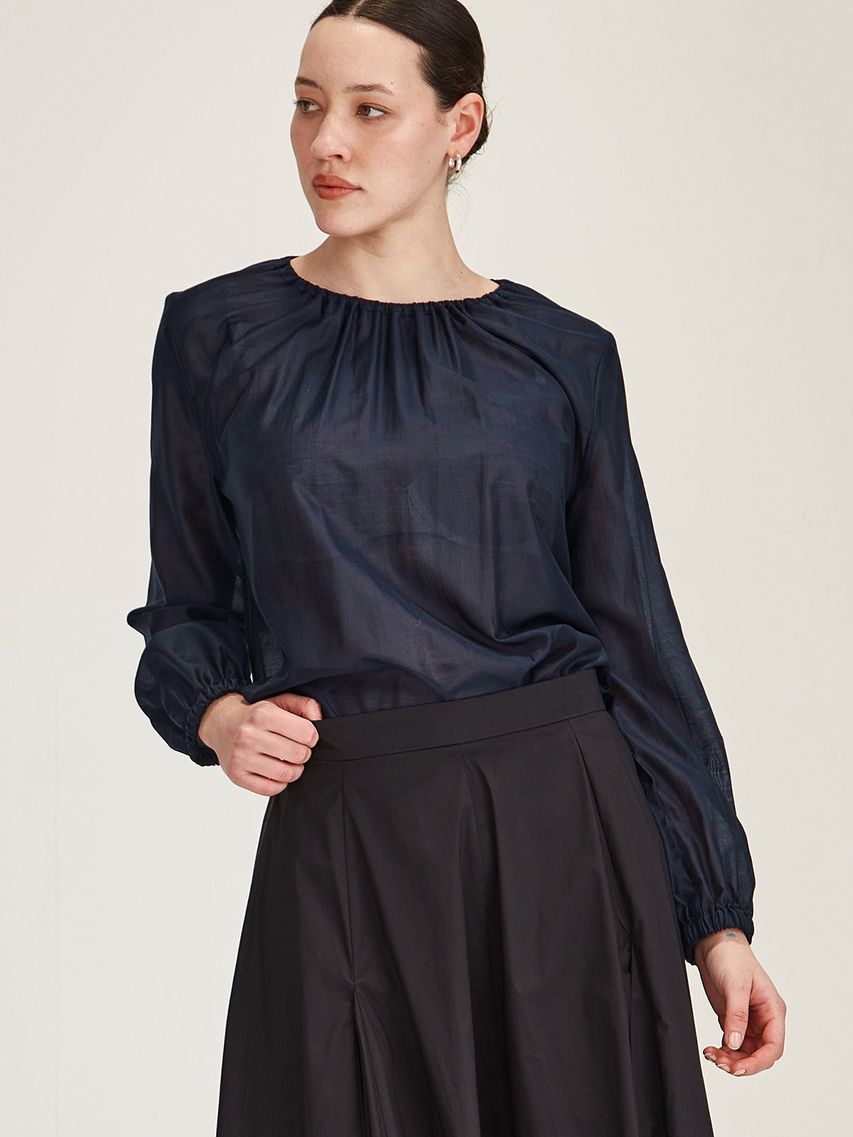 close up of woman wearing Sills Anna chiffon blouse Top in Navy against grey background