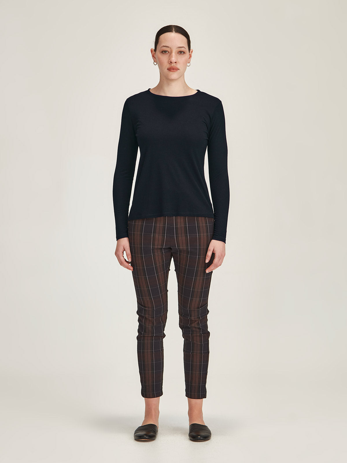 woman against grey background wearing Sills navy merino blend Lena long sleve Tee with chocolate plaid Hpeburn pull on pants