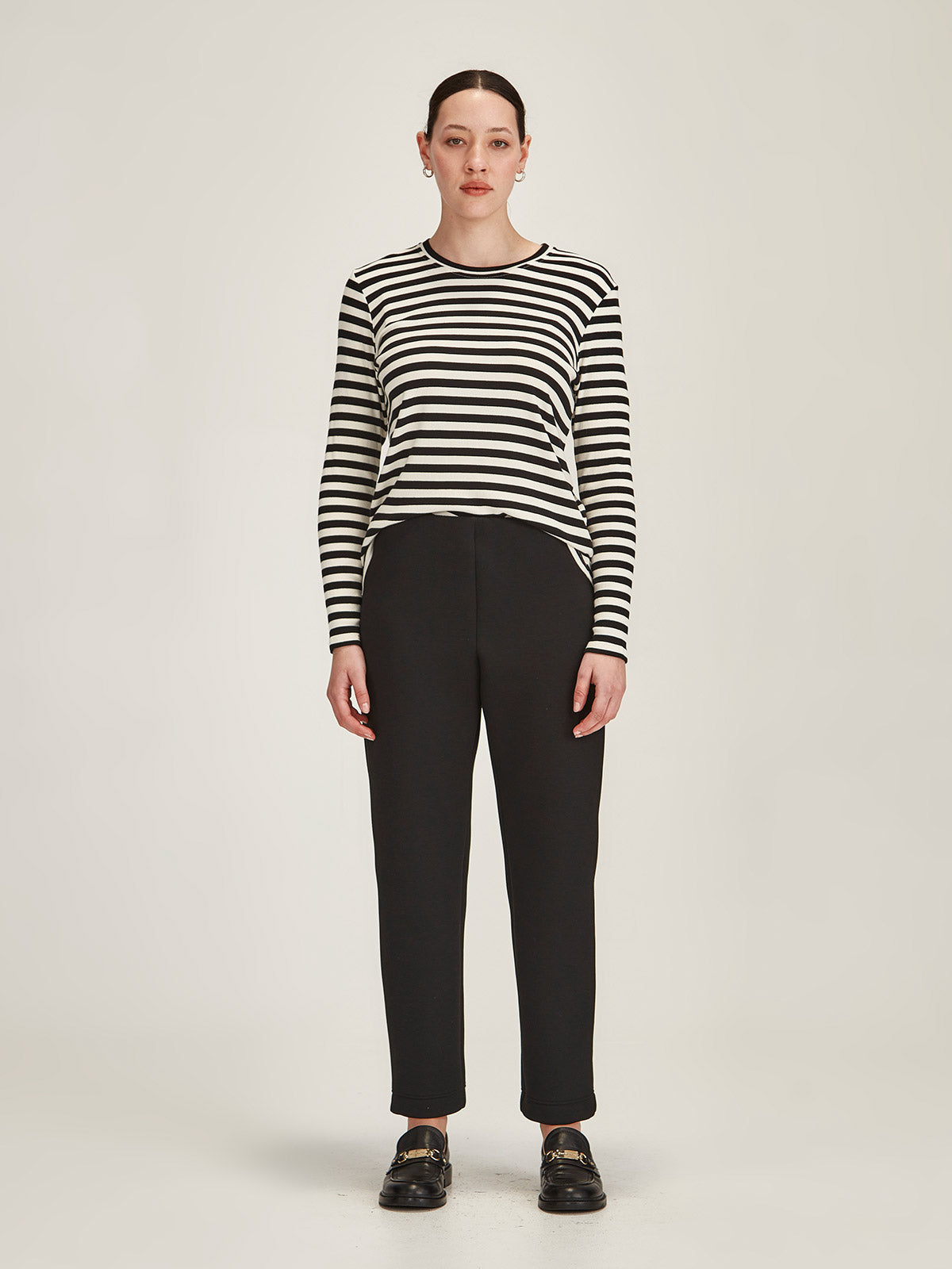 woman against grey background wearing Sills black/ivory striped crew neck long sleeve top and black Kathryn scuba pants