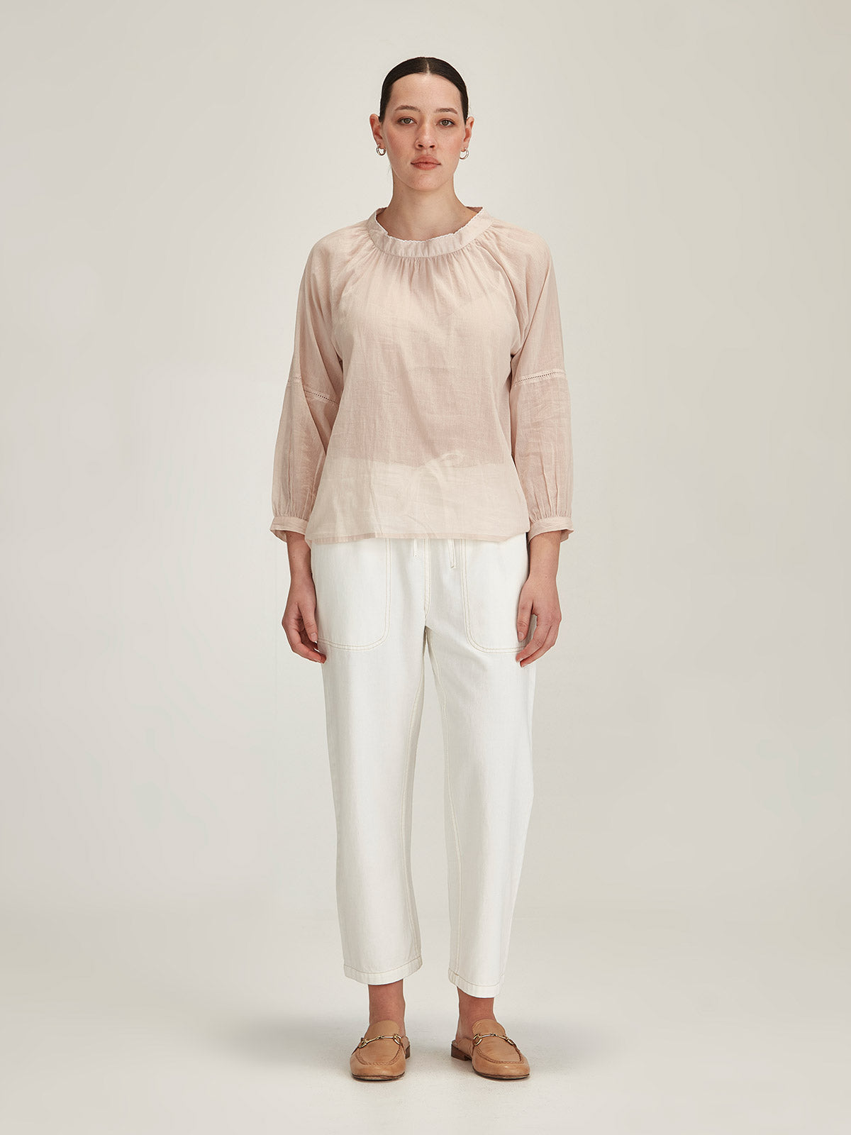 Model wears a Sills beige organic cotton Hana Embroidered Top with chalk Ginza Drawstring Jeans in front of grey background