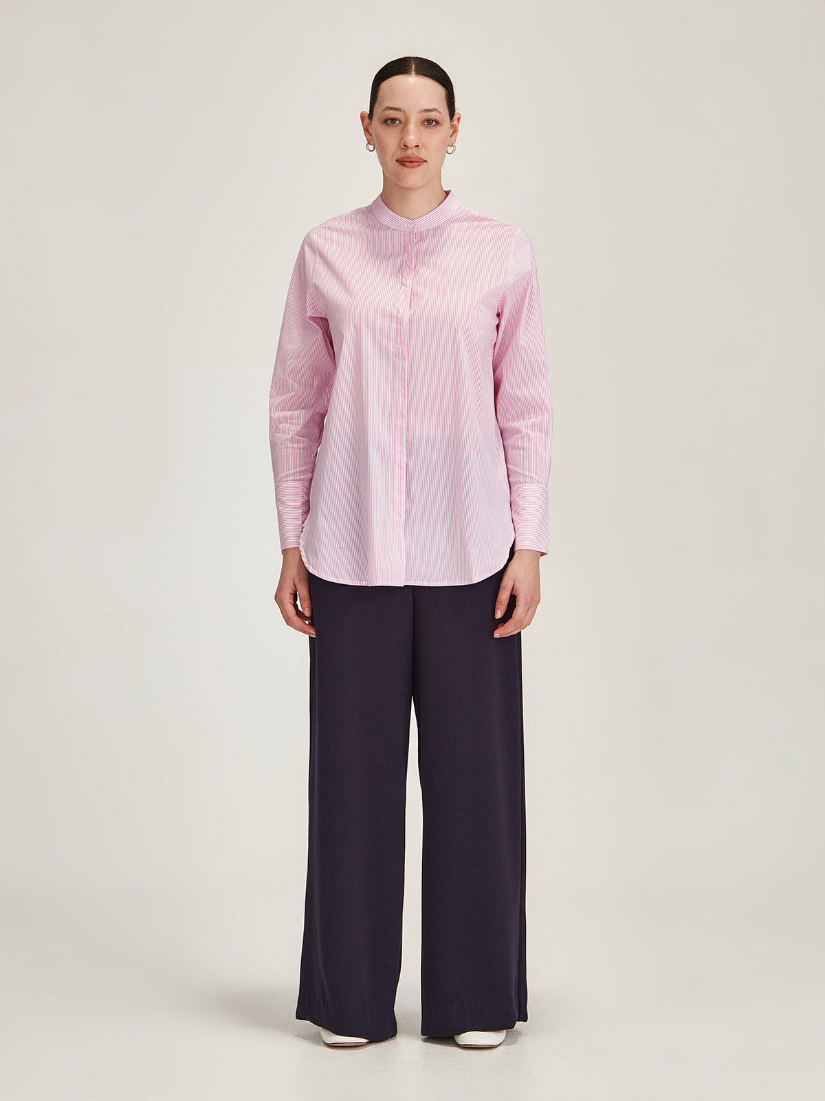 woman wearing Sills pink Koda Striped Shirt and navy Luca Wide Leg Pant on grey background