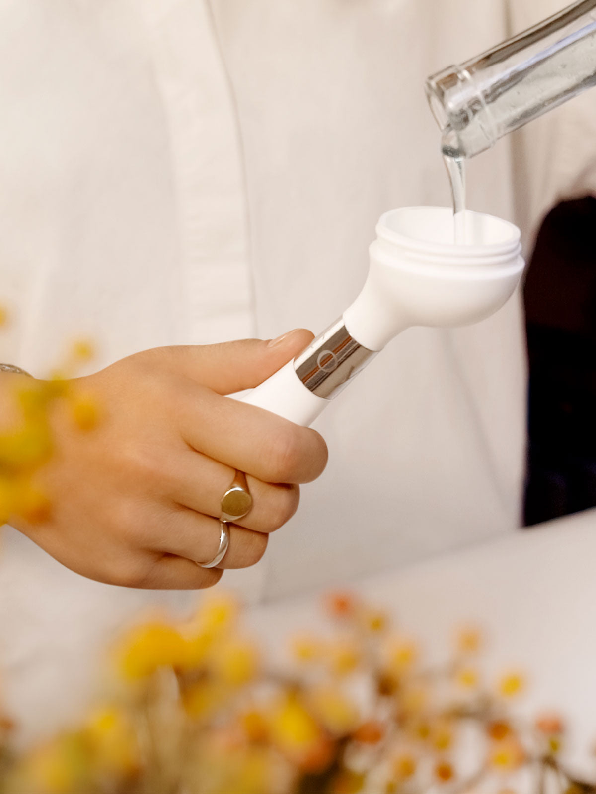 The One Brush V2 Suction by Yeseco - Hand filling the white brush handle with water from a tap, demonstrating the wide-neck refill system for the integrated soap dispenser.
