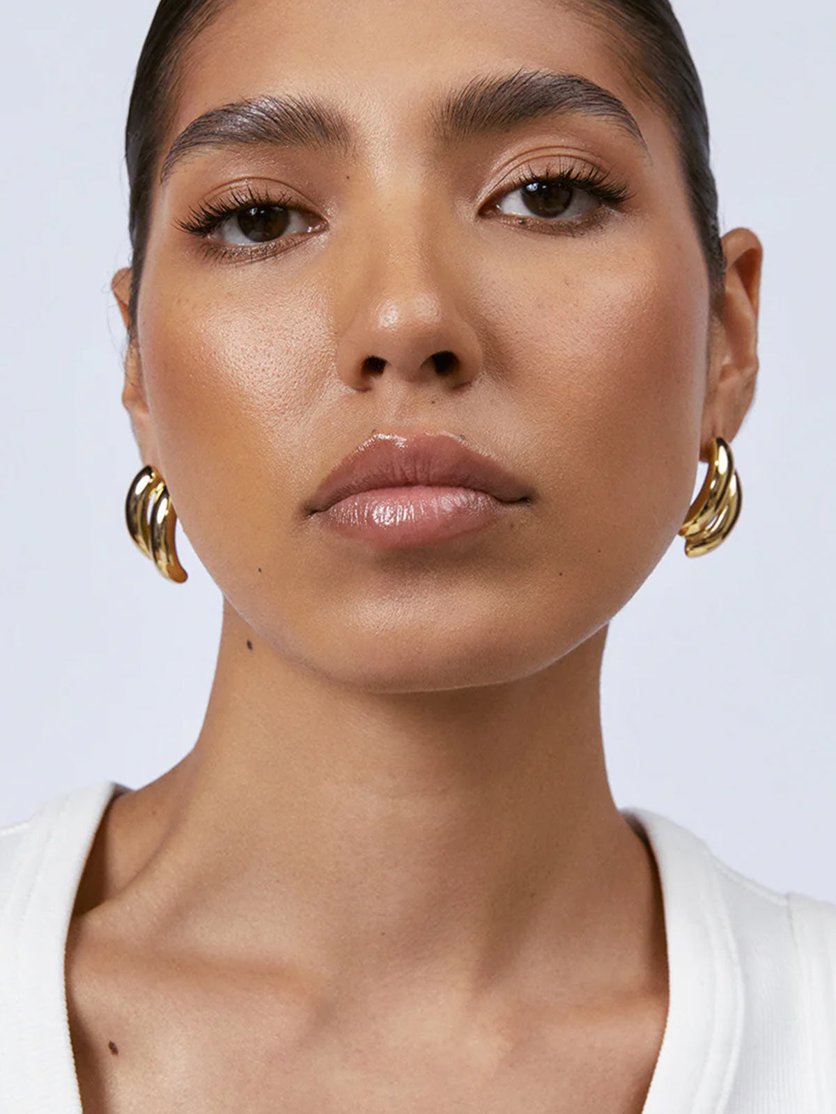 Zahar Claire gold earrings (Z266) shown from the front on a model, highlighting the dimensional aspects and craftsmanship of the earring design.