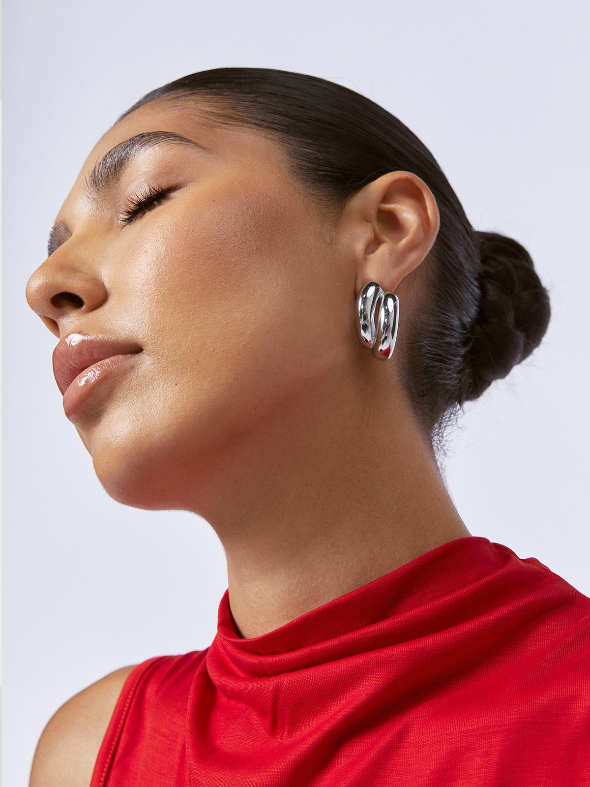 Zahar Claire silver earrings (Z266) shown from the left side on a female model, highlighting the dimensional aspects and craftsmanship of the earring design.