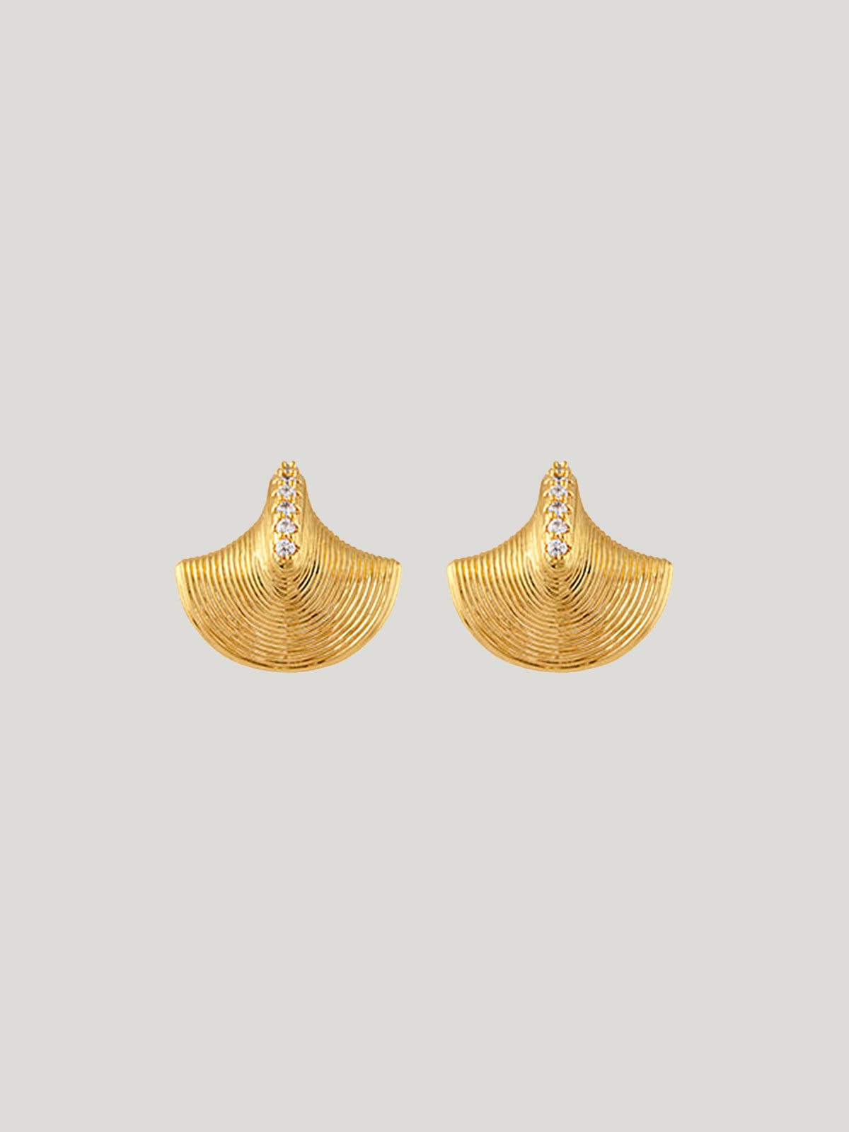 Aubree Earrings by Zahar in gold plated brass on a grey background. Stunning fan-shaped design with fine ridged details and a row of sparkling cubic zirconia stones for added elegance.